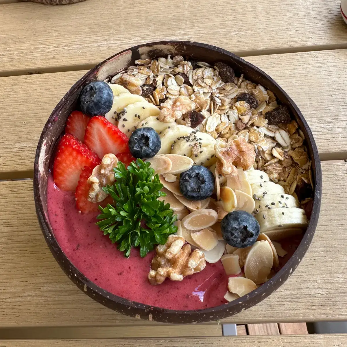 Berry Bliss smoothie bowl topped with fresh fruit, granola and seeds at Thongyib Thongyod