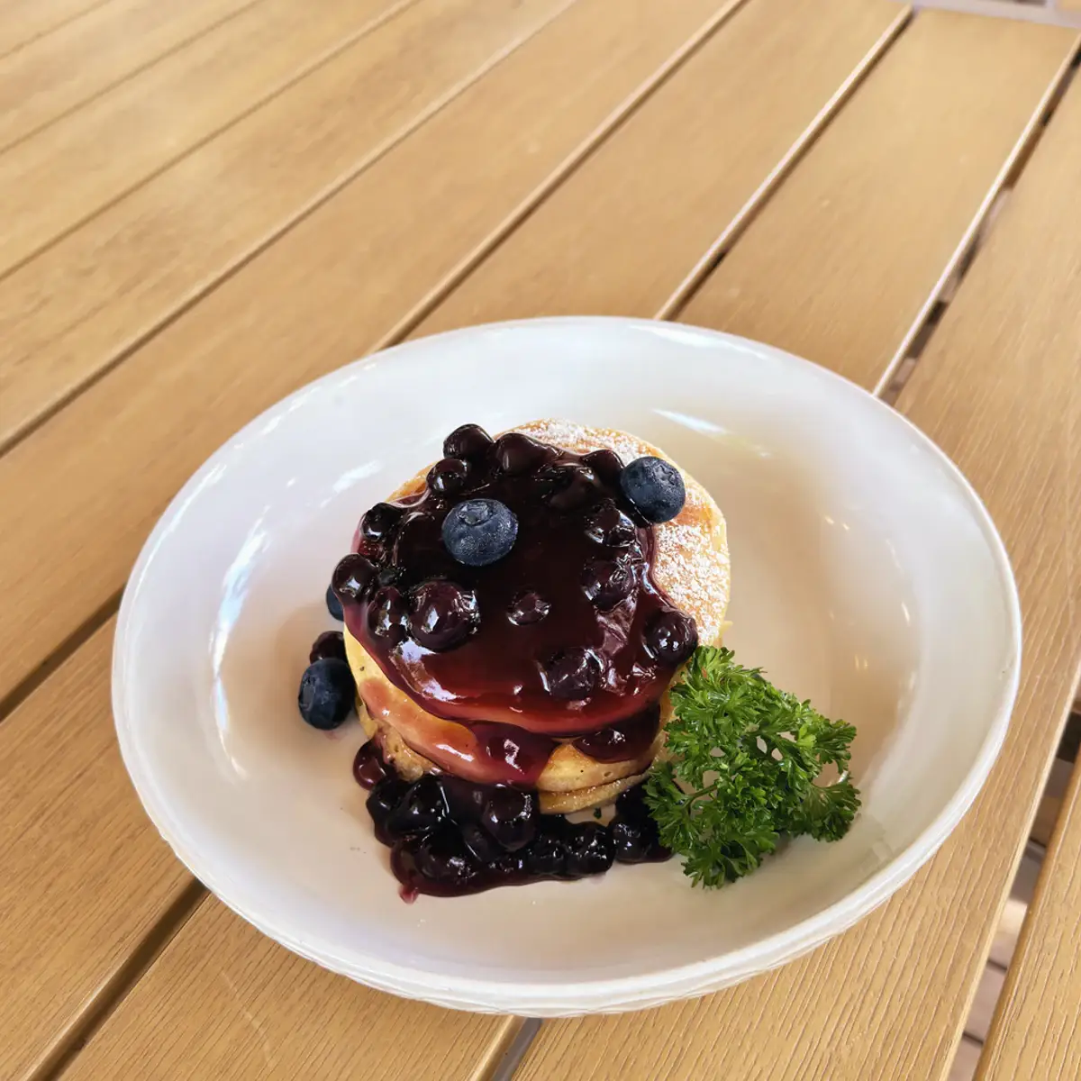 Blueberry pancakes with fresh blueberries, homemade blueberry jam and icing sugar