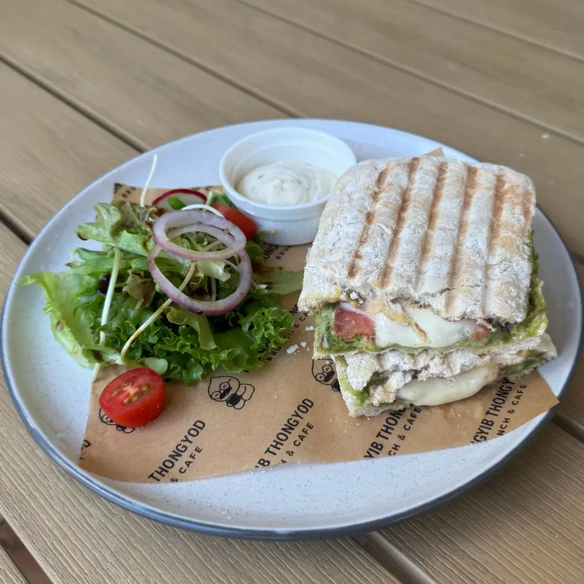 A caprese ciabatta panini with tomato and melted cheese, grilled to order
