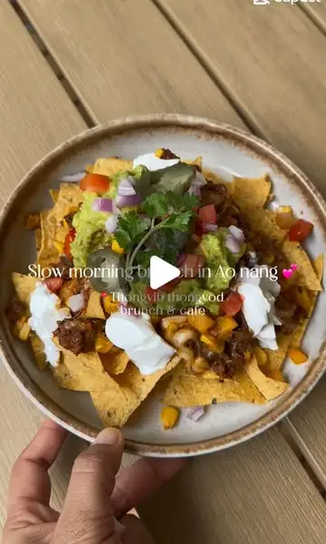 Loaded beef nachos con guacamole e sour cream sul tavolo di legno — video brunch di una mattina lenta