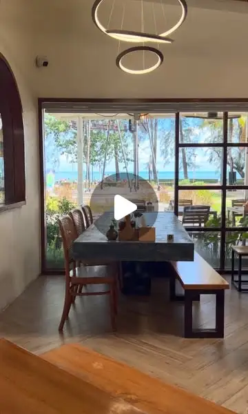 Il lungo tavolo vicino alla finestra con vista sul mare e sui casuarina di Nopparat Thara