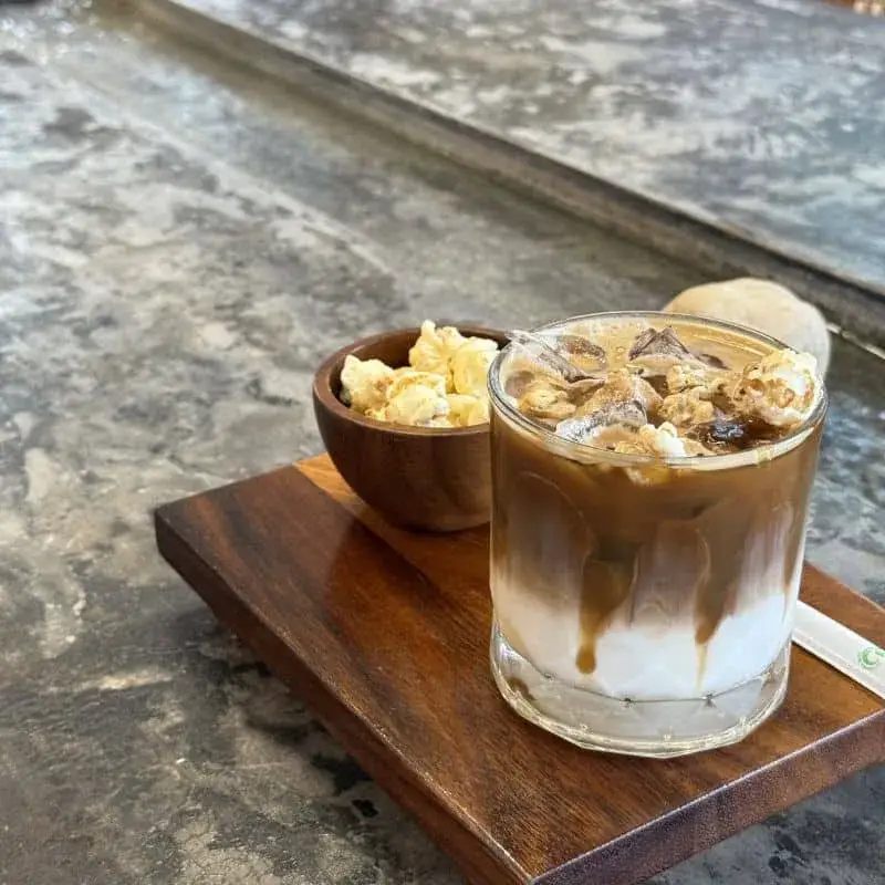 카페의 Popular Coffee와 나란히 놓인 크로플. 캐러멜, 팝콘, 에스프레소가 테이블 위에 함께합니다