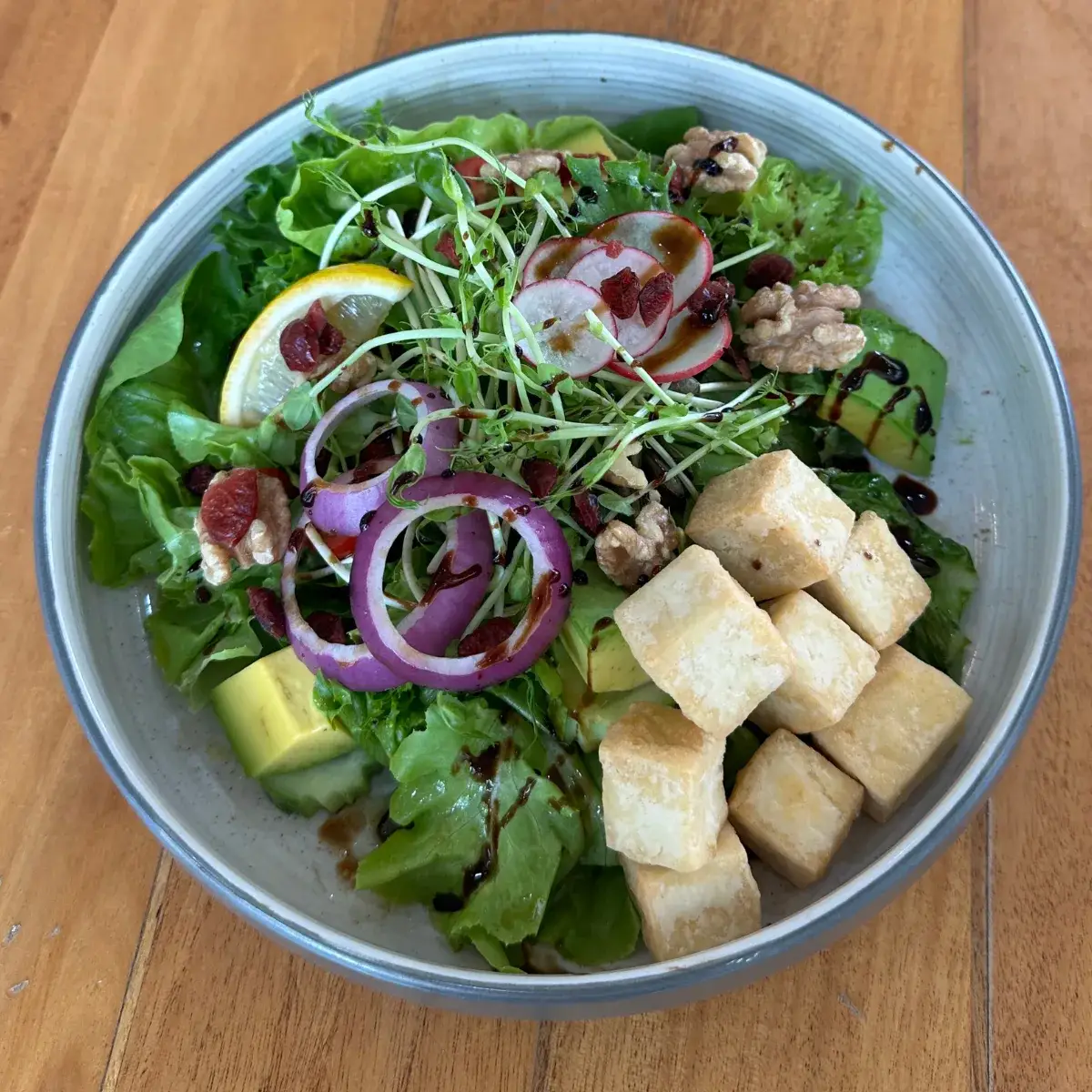 Tofu and avocado salad — tofu, avocado, mixed leaves and seeds — in a bowl at Thongyib Thongyod
